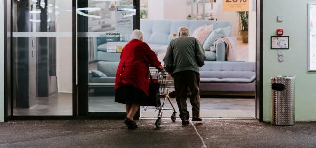 man in red shirt and black pants sitting on black and silver wheel chair by Claudio Schwarz courtesy of Unsplash.