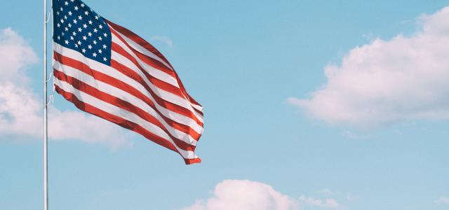 flag of U.S.A. under white clouds during daytime by Aaron Burden courtesy of Unsplash.